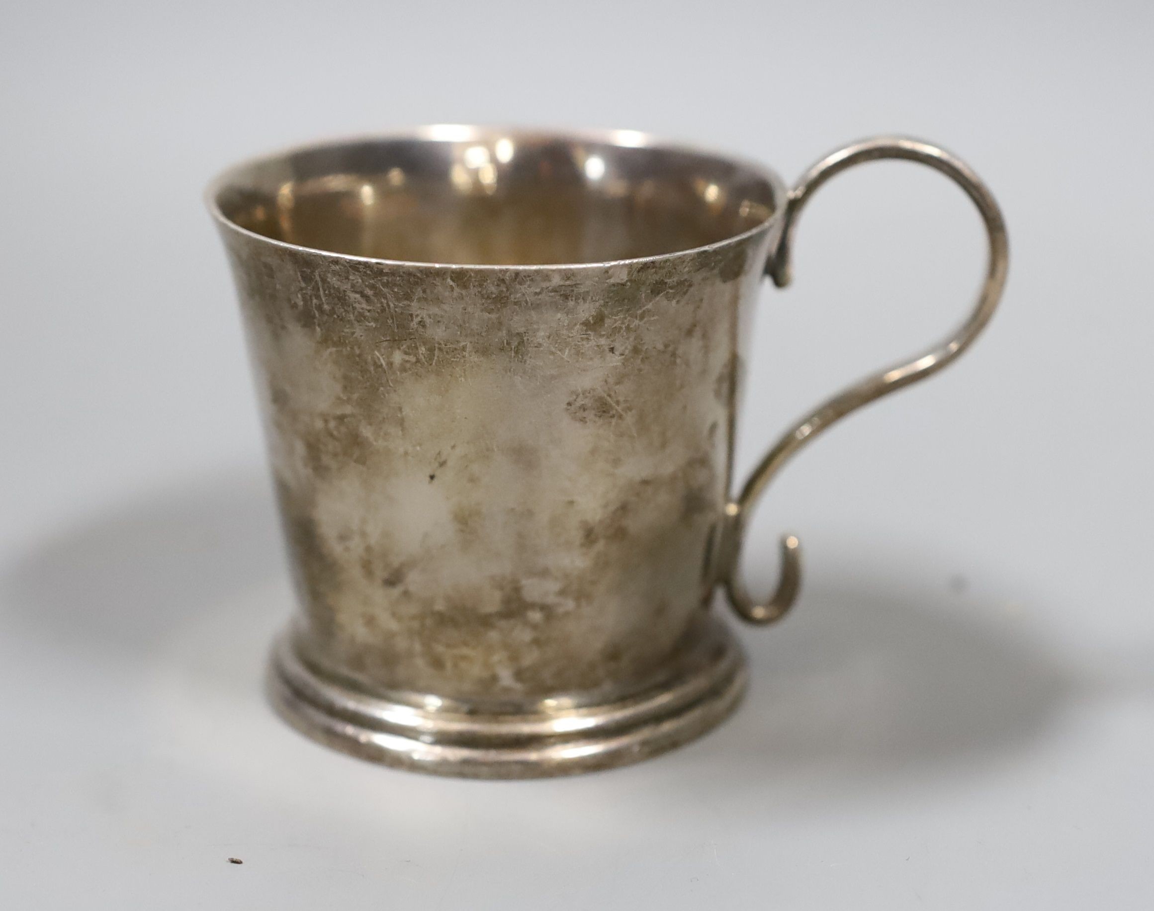 A modern Irish silver christening mug, Royal Irish Silver Co. Dublin, 1974, retailed by Asprey, London, 7cm, a late Victorian silver sovereign case, a gilt metal locket, part of a child's silver rattle and a polychrome e